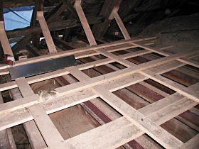 Pohled do prostoru krovu na konstrukci vynášející část stropu hrozící zřícením, stav na konci roku 2004.
