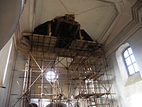 Lešenové věže v lodi kostela podpírající strop a krov.